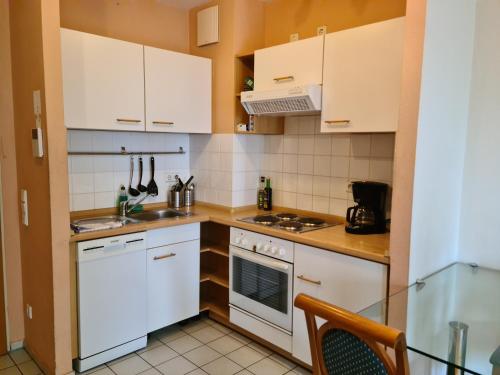 una cocina con armarios blancos y electrodomésticos blancos en TopDomizil Apartments Checkpoint Plaza en Berlín