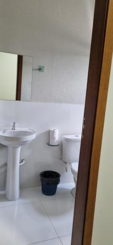 a bathroom with a sink and a toilet and a mirror at Nathus Hotel in Chapadão do Sul