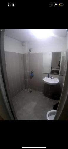 a bathroom with a sink and a toilet and a mirror at By thor Bintaro plaza residance in Pondoklang