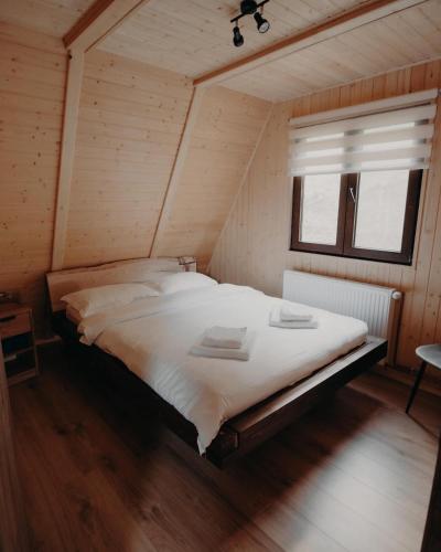 a large bed in a room with a window at Atipic Chalet in Holda