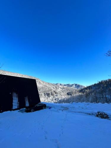 a building is covered in snow in a field at Atipic Chalet in Holda