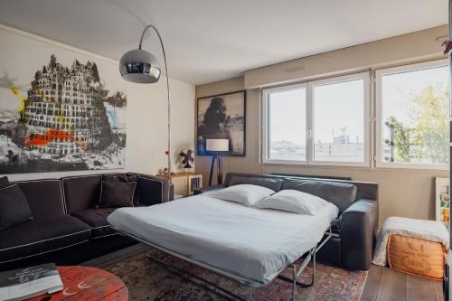 a bedroom with a bed and a couch at Veeve - Visual Exultation in Boulogne-Billancourt