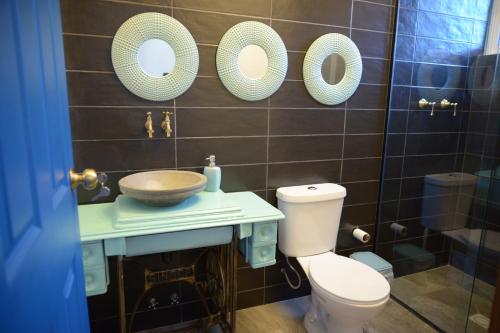 a bathroom with a toilet and a sink and mirrors at Casa de Campo Solar Tere in Cochabamba