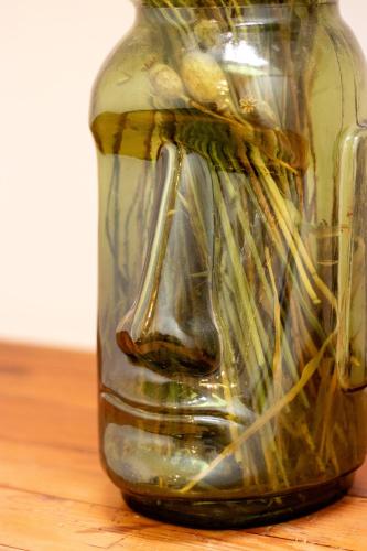 a glass jar sitting on top of a wooden table at Le Grand Ker - Gîte de Charme in Plougasnou
