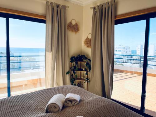 1 dormitorio con cama y vistas al océano en Pérola do Algarve en Quarteira