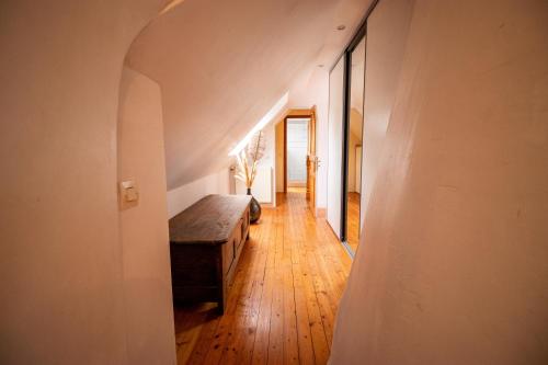 an attic hallway with a bench in a room at Le Grand Ker - Gîte de Charme in Plougasnou