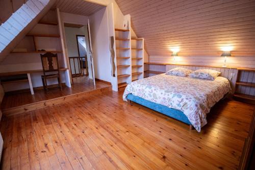 a bedroom with a bed and a wooden floor at Le Grand Ker - Gîte de Charme in Plougasnou