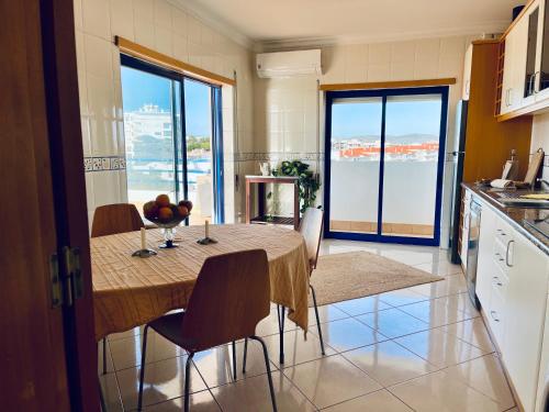 a kitchen with a table and chairs in a kitchen at Pérola do Algarve in Quarteira