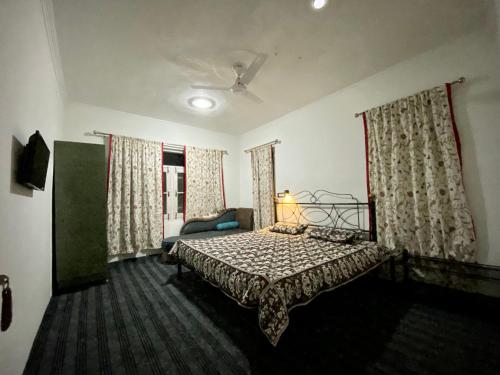 - une chambre avec un lit, un canapé et des fenêtres dans l'établissement Serene Villa with Beautiful View of Glaciers, à Srinagar
