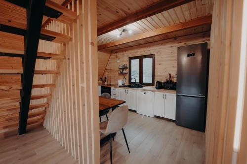 a kitchen with a refrigerator and a wooden wall at Atipic Chalet in Holda