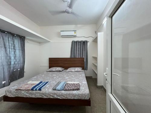 a small bedroom with a bed and a window at SAIBALA HOMESTAY - AC 1 BHK NEAR AlRPORT in Chennai