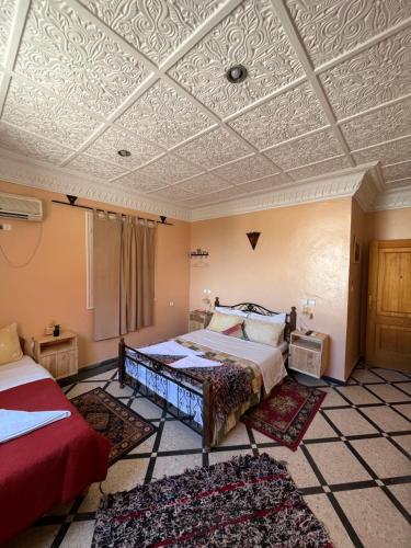 een slaapkamer met 2 bedden en een schuin plafond bij Diyar Timnay in Moulay Idriss Zerhoun