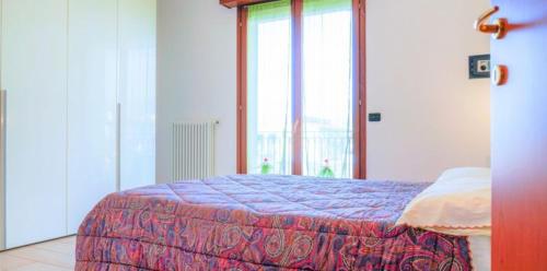 Vis Bella Apartment في ريميني: غرفة نوم بسرير ونافذة كبيرة