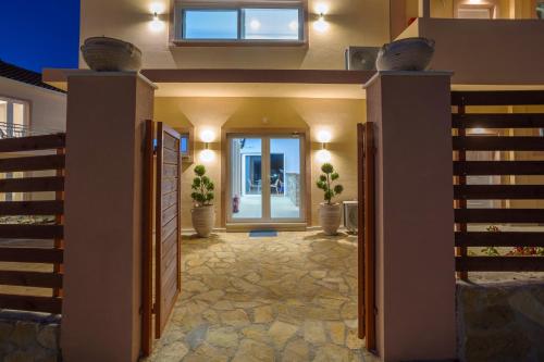 a house with a hallway with doors and potted plants at Mary Elen Boutique Hotel in Argasi