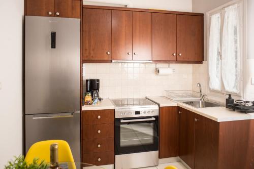 a kitchen with wooden cabinets and a stainless steel refrigerator at Historical center small diamond in Kalamata