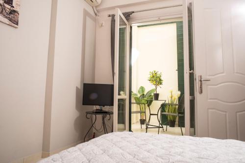 a bedroom with a bed and a tv and a door at Historical center small diamond in Kalamata