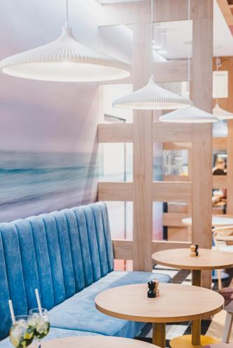a room with a blue couch and tables at GRANO APARTMENTS Gdańsk Old Town SPA & Wellness - GRANO APARTMENTS Gdańsk Residence SPA & Wellness in Gdańsk