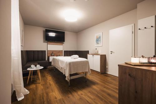 a room with a bed and a table and a couch at Ferienhäuser Baltic Lagoon Haus 14a in Fuhlendorf
