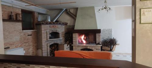 a living room with a brick fireplace with an orange couch at La dimora dei Sanniti in Busso