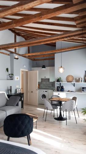 a living room with a table and chairs and a kitchen at Casa de las Lías in Chinchón