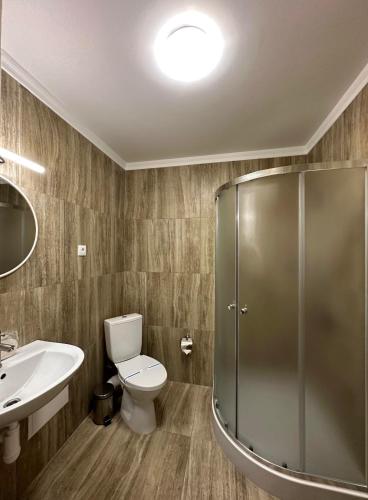 a bathroom with a shower and a toilet and a sink at Garden Hall in Ternopilʼ