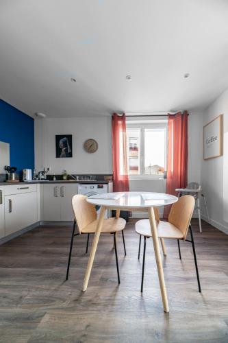 a kitchen with a table and chairs in a room at Résidence Léon Blum - Appartements design - Parking in Clermont-Ferrand