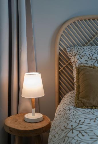 a lamp on a table next to a bed at Résidence Léon Blum - Appartements design - Parking in Clermont-Ferrand