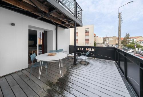 a balcony with a white table and chairs at Résidence Léon Blum - Appartements design - Parking in Clermont-Ferrand