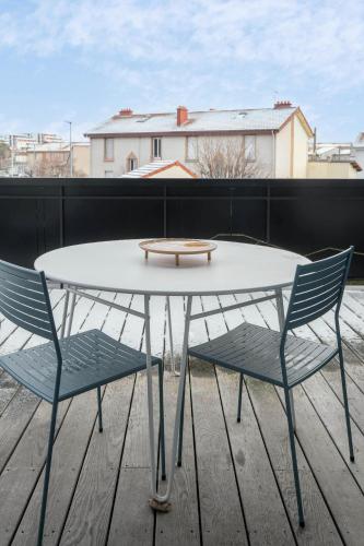 a white table and two chairs on a balcony at Résidence Léon Blum - Appartements design - Parking in Clermont-Ferrand