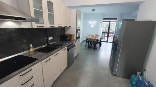 a kitchen with white cabinets and a black refrigerator at MRȘ House 2 in Bucharest