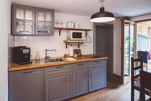 a kitchen with gray cabinets and a sink at Chalet am Sonnenhang in Obertraun
