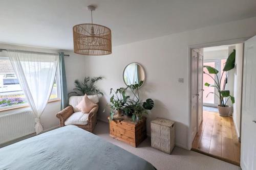 1 dormitorio con cama, silla y espejo en 1 Mint Park Road, en Braunton