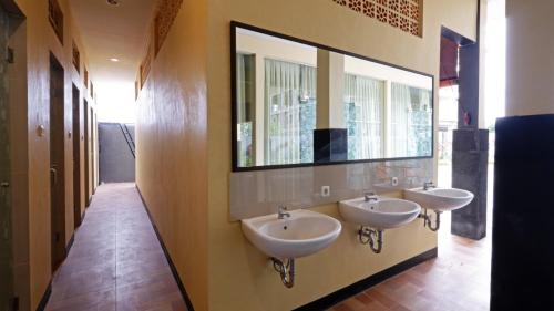 a bathroom with two sinks and a large mirror at V Canggu Dormitory in Canggu
