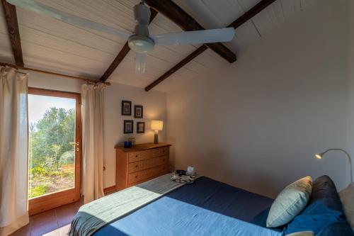 Un dormitorio con una cama azul y una ventana en Villetta indipendente sul Mare, en Monte Argentario