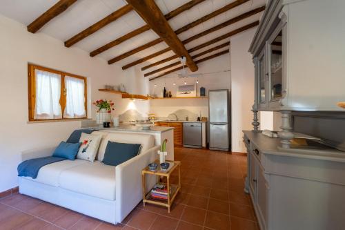 uma sala de estar com um sofá branco e uma cozinha em Villetta indipendente sul Mare em Monte Argentario