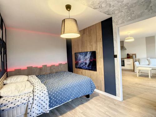 een slaapkamer met een bed met een polka dot-deken bij La Pommedepin Ravissante maisonnette avec jardin in Plouescat