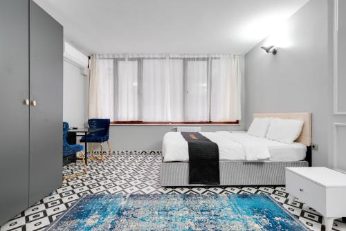 Schlafzimmer mit einem Bett, einem Tisch und einem Fenster in der Unterkunft Portist Hotel in Istanbul
