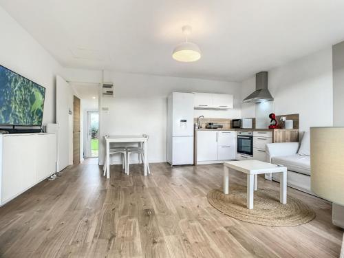 un salon avec une table et une cuisine dans l'établissement La Pommedepin Ravissante maisonnette avec jardin, à Plouescat