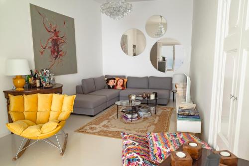 a living room with a couch and a yellow chair at Casa Salvi Positano in Positano