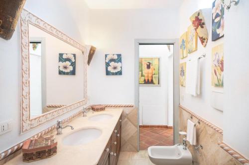 bagno con 2 lavandini e specchio di Domus Siracleto Villa, Notteri, Porto Giunco, pool a Notteri