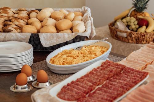 a table with eggs and meats and other foods at Hotel Belvedere San Gottardo by LVG Hotel Collection in Verbania