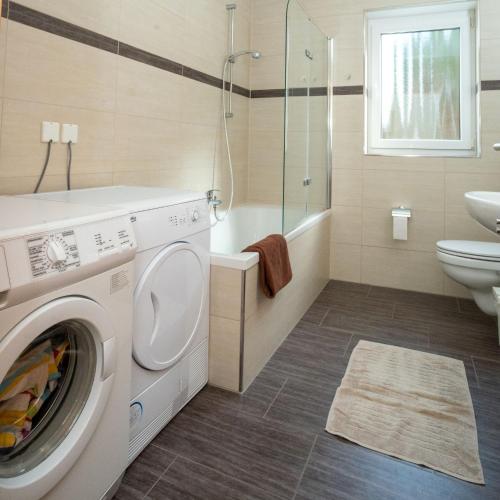 a bathroom with a washing machine and a sink at Ferien im Maigen in Mettlach