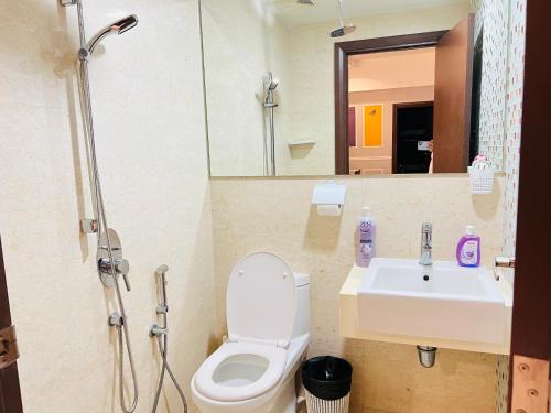 a bathroom with a toilet and a sink and a shower at Empire Hostel Regalia in Kuala Lumpur