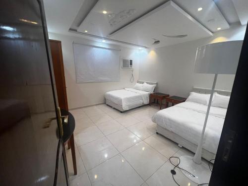 ‘Awaliにある8 Luxury housing شقة فاخرのベッド2台と壁にチョークボードが備わる客室です。