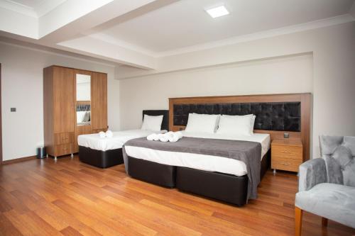 a hotel room with two beds and a chair at Türkler Suite Hotel in Trabzon