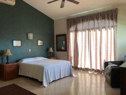 um quarto com uma cama e uma grande janela em Delfin bnb em Cruz de Huanacaxtle