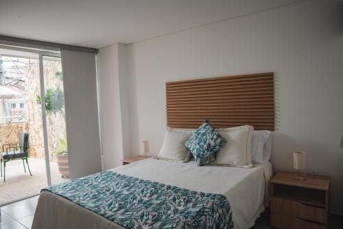 a bedroom with a bed with blue and white pillows at COLIBRI Gorgeous new flat with balcony and terrace in Cali