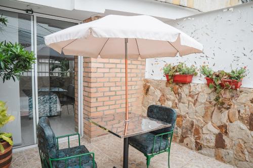 a table and chairs with an umbrella on a patio at COLIBRI Gorgeous new flat with balcony and terrace in Cali
