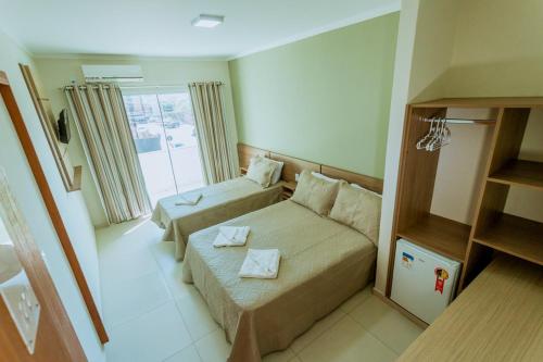 ein Hotelzimmer mit einem Bett und einer Couch in der Unterkunft Litoral Hotel Arroio do Sal in Arroio do Sal