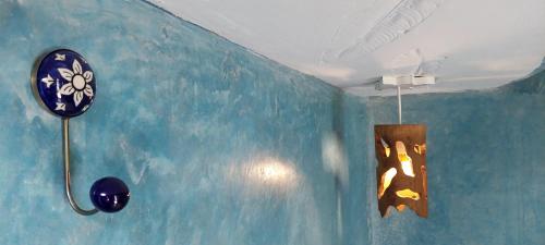 a blue wall with a painting of a giraffe on it at Matsya in Havelock Island